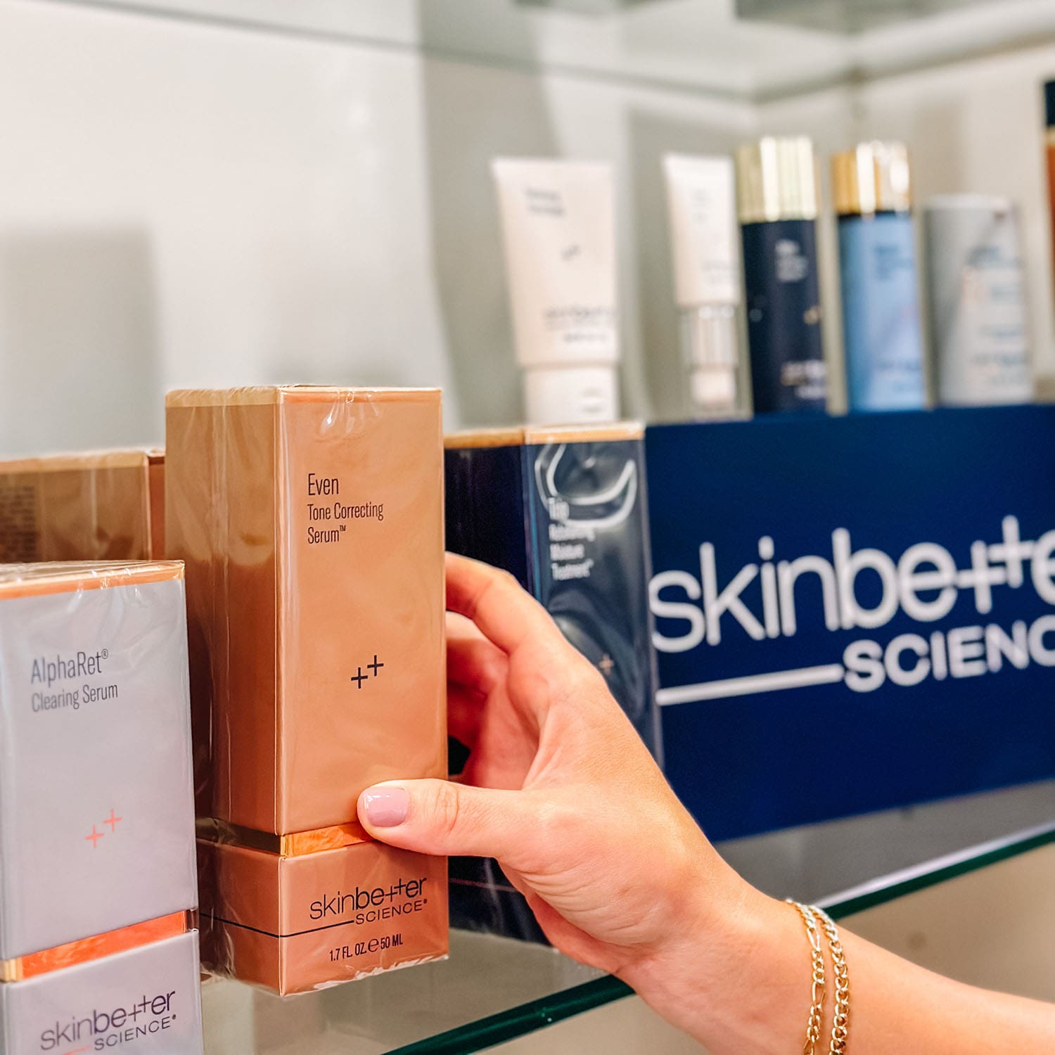 Woman's hand reaching for skincare product box on store shelf